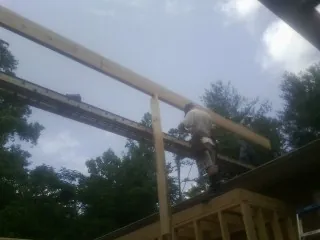 Carpenter setting a ridge beam over a new addition frame — Ice Dam Removal by Roofing Brothers in Beacon