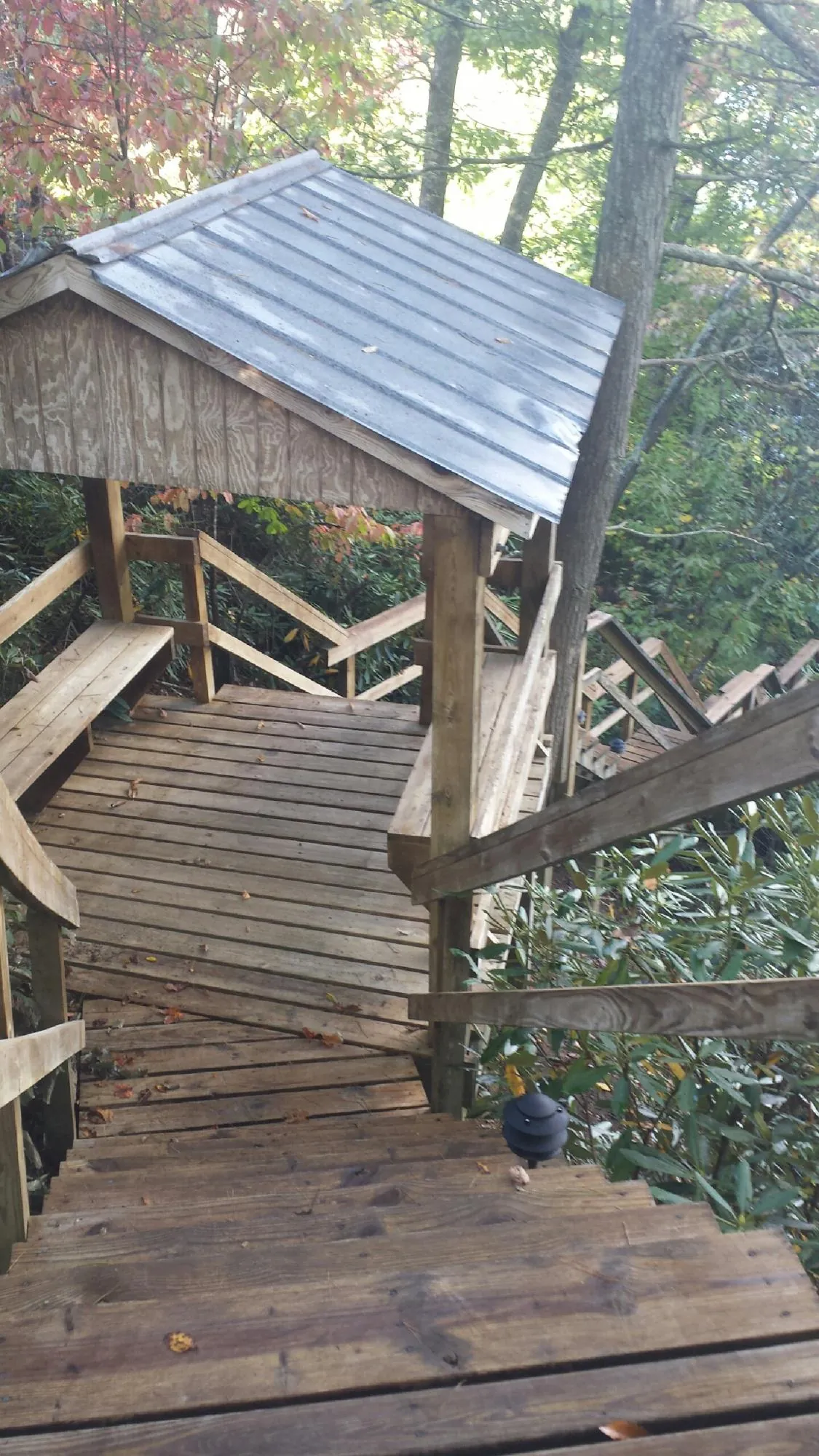 Metal roofed shelter over wooden steps on a wooded walkway — Skylight Repair & Installation work by our crew in Beacon